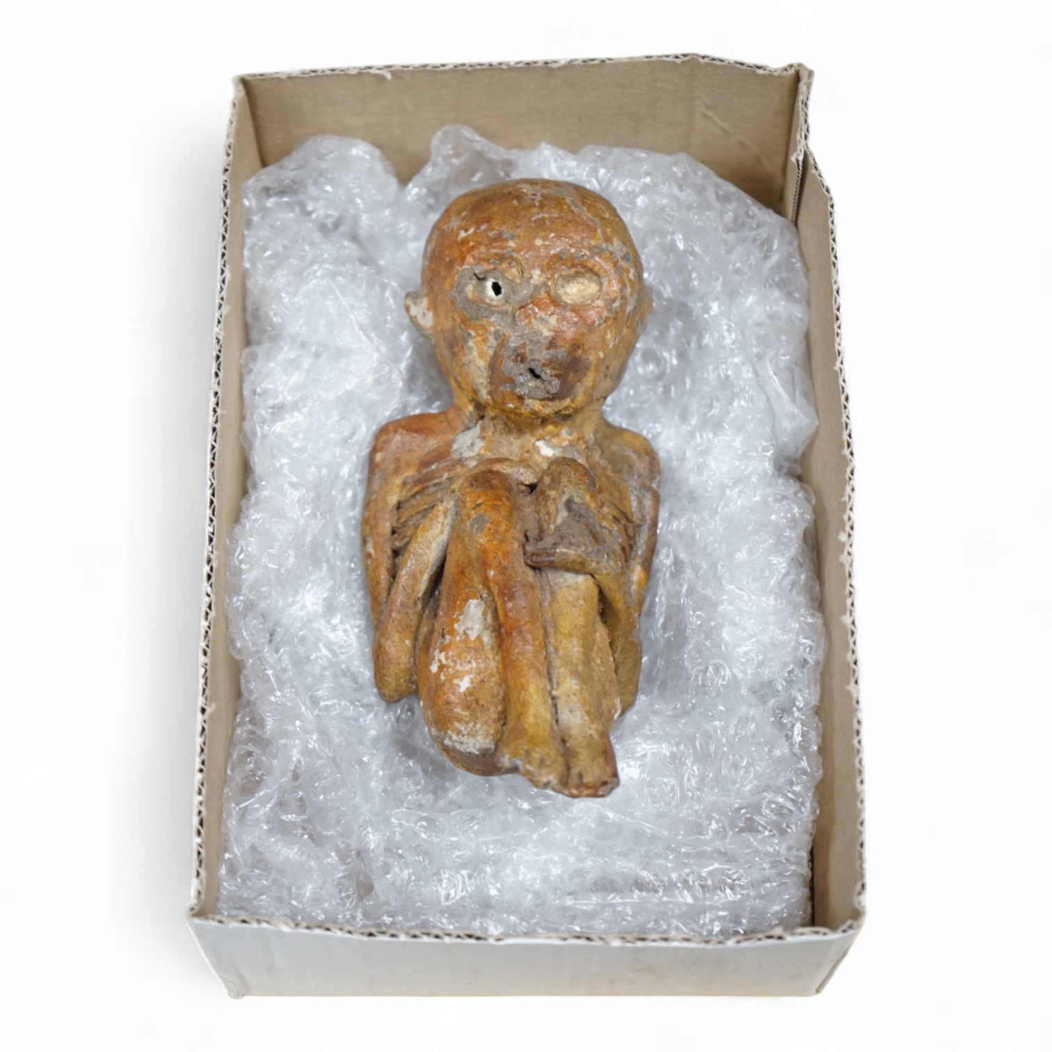 A Kuman Thong Indonesian ‘good fortune’ baby spirit figure in a foetal position, made from the sap of the kwak tree (Korean lacquer tree). Condition - fair to good.